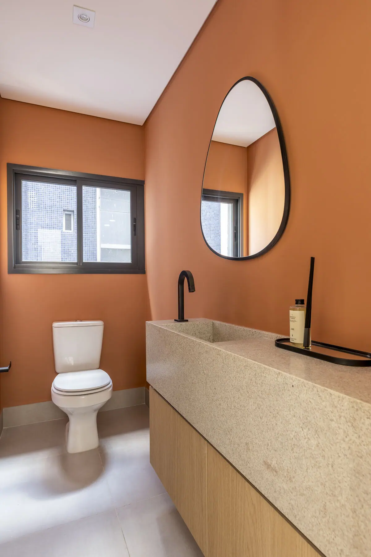 Lavabo com parede terracota e cuba esculpida em pedra